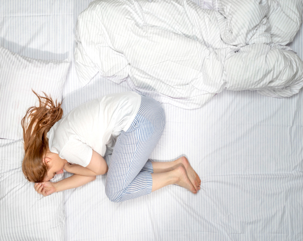 Various poses of a sleeping woman. Female side sleeper fetal position, on the back, on her side, face down on stomach in bed. Deep restful sleep. Girl lying in a nightie pajamas on white bed linen toss-and-turn-sleeper